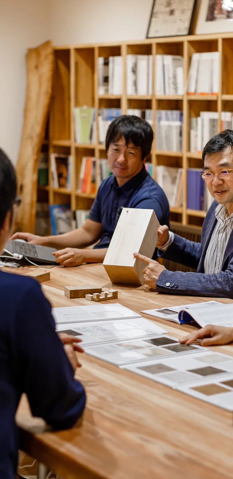 木材サンプルを使って打ち合わせする設計チーム